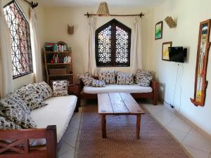 a living room with two couches and a window at Swahili Oasis in Diani Beach