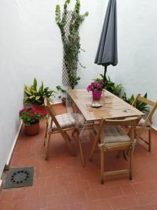 una mesa, sillas y una sombrilla en el patio en Apartamento El Nido en La Guardia