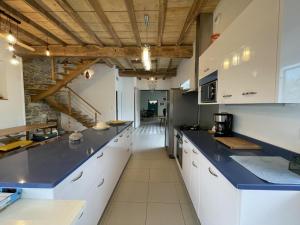 duża kuchnia z białymi szafkami i niebieskimi blatami w obiekcie Eiherabidia w mieście Orsanco