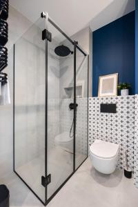 W łazience znajduje się przeszklony prysznic i toaleta. w obiekcie Kasprzaka Blue Comfort Apartment w Warszawie