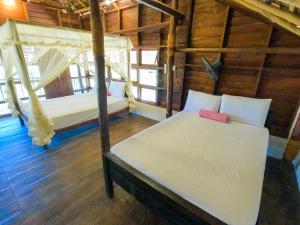 a bedroom with two beds in a wooden cabin at The Cove Pasikuda - Eco Resort in Pasikuda