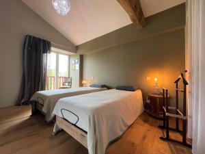 a bedroom with two beds and a large window at Eiherabidia in Orsanco