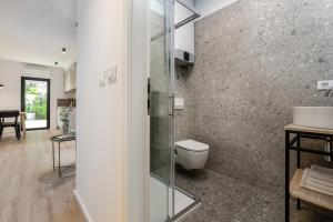 La salle de bains est pourvue d'une douche en verre et de toilettes. dans l'établissement Upper Sea View Apartments, à Vrsar
