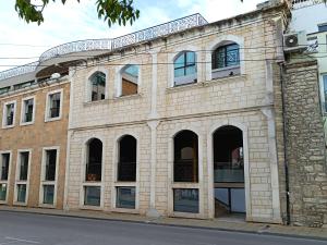 巴尔奇克Апартамент Арките的街道上一座带拱形窗户的旧砖砌建筑