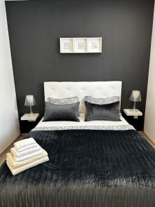 a bedroom with a black and white bed with two lamps at Apartmani Mutogras in Podstrana
