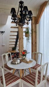 une table à manger avec des chaises et un lustre dans l'établissement DIENVIDI, à Bernāti