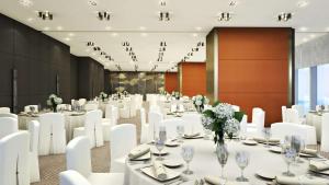 a banquet hall with white tables and white chairs at Grand Hyatt Jeju in Jeju