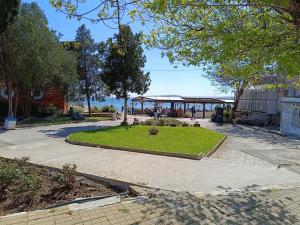 Un parque con una zona de césped con un pabellón. en Апартамент Арките, en Balchik