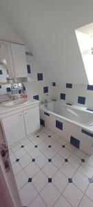 La salle de bains blanche est pourvue d'une baignoire et d'un lavabo. dans l'établissement Maison de vacances - Baie du Mont Saint Michel, à Saint-Jean-le-Thomas
