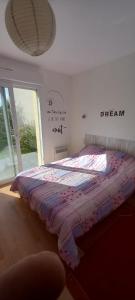 - un lit dans une chambre avec fenêtre dans l'établissement Maison de vacances - Baie du Mont Saint Michel, à Saint-Jean-le-Thomas