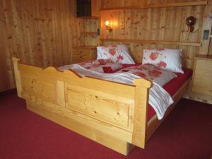 sypialnia z drewnianym łóżkiem w pokoju w obiekcie Ferienhaus Nussbaumer w mieście Sibratsgfäll