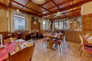 ボーデンマイスにあるHotel Bayerischer Hofのテーブルと椅子が備わるウッドフロアのレストランを併設しています。