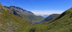 um grupo de pessoas em pé sobre uma colina com vista para um vale em Appartement Matiski em Vaujany