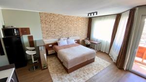 a hotel room with a bed and a brick wall at Delux apartment in Bansko for two in Bansko