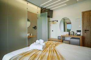 a bedroom with a bed with towels on it at Omnia Deluxe Rooms in Parga