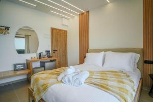 a bedroom with a bed with towels on it at Omnia Deluxe Rooms in Parga