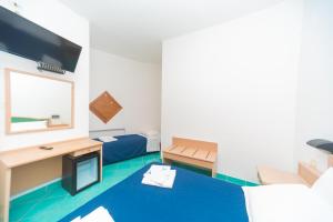a room with two beds and a desk at Hotel America in Marina di Camerota