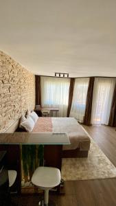 a bedroom with a large bed and a stone wall at Delux apartment in Bansko for two in Bansko