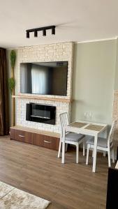 a living room with a table and a fireplace with a tv at Delux apartment in Bansko for two in Bansko