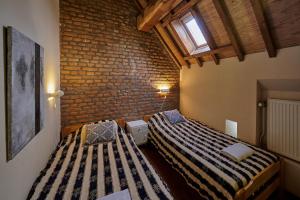 een slaapkamer met 2 bedden en een bakstenen muur bij Meschermolen 3 in Withuis