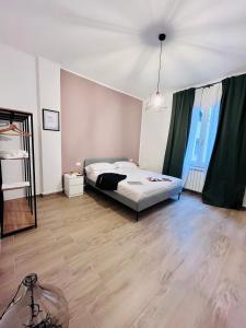 a bedroom with a bed and a wooden floor at A Pisa con amore in Pisa