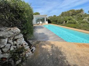 una piscina accanto a una casa con un muro di pietra di Luxury studio with private pool a Binisafua