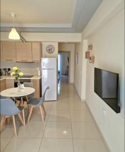 a kitchen with a table and a white refrigerator at luxury - comfy center rodos in Asgourou