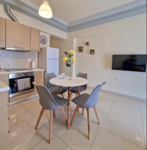a kitchen with a table and two chairs and a table at comfy center rodos - luxury in Asgourou