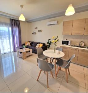 a kitchen and a living room with a table and chairs at luxury - comfy center rodos in Asgourou