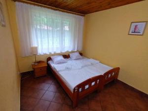Schlafzimmer mit einem großen Bett und einem Fenster in der Unterkunft Lipowy Przylądek - Domek 1 