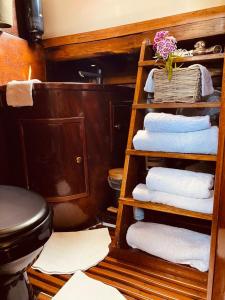 een badkamer met een stapel handdoeken en een toilet bij Le Damona in Merbes-le-Château