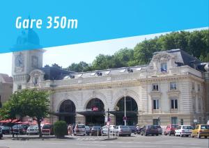 een groot gebouw met auto's geparkeerd voor het bij Baiona Sainte Cath -4-Lau- au cœur de Saint Esprit in Bayonne