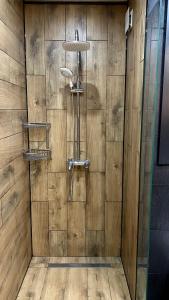 a shower in a wooden wall with a shower head at Delux apartment in Bansko for two in Bansko