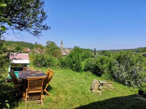 uma mesa e cadeiras num quintal relvado em Belle vue au coeur de la verdure em Aisey-sur-Seine