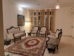 a living room with chairs and a rug at BluSalzz Villas - The Pine Tree, Dalhousie - Himachal Pradesh in Dalhousie
