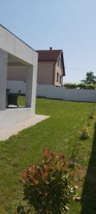 a house with a green yard with a building at Vila Andrea in Oradea
