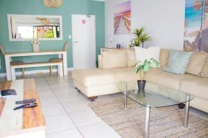 a living room with a couch and a table at 150 The Blyde Crystal Clear Lagoon 3 Bedroom Garden Apartment in Pretoria
