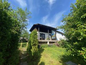 una pequeña casa blanca con techo negro en Lavender and Poppy cottages en Bebrovo