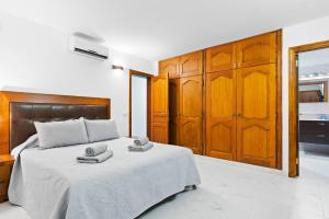 1 dormitorio con 1 cama con 2 toallas en Neptuno Pool and beach private access en Puerto de Santiago