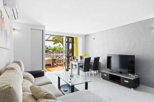 uma sala de estar com um sofá, uma televisão e uma mesa em Neptuno Pool and beach private access em Puerto de Santiago