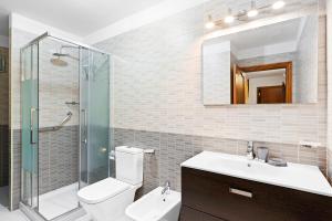 a bathroom with a toilet and a sink and a shower at Neptuno Pool and beach private access in Puerto de Santiago +23 photos