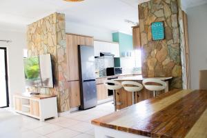 a kitchen with a counter and stools at 150 The Blyde Crystal Clear Lagoon 3 Bedroom Garden Apartment in Pretoria