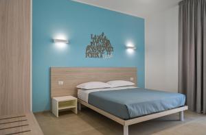 een slaapkamer met een bed en een blauwe muur bij Terra Home Resort in Spongano +10 foto's