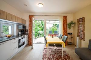 a kitchen with a table and a dining room at Apartments im Garten - Haus Daniela in Graz