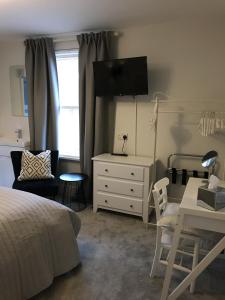 um quarto com uma cama, uma cómoda e uma secretária em The Glastonbury Townhouse B&B em Glastonbury