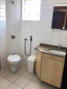 a bathroom with a toilet and a sink at Triplex Cor de Chicletes in Curitiba