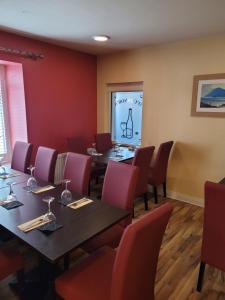 a dining room with tables and red chairs at O'Connors Bar Restaurant and Guesthouse in Dromore
