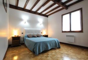 a bedroom with a bed with blue sheets and two lamps at Iparla in Urrugne