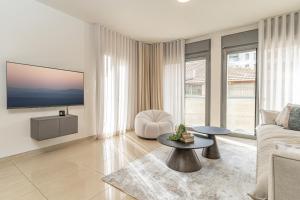 ein Wohnzimmer mit einem Sofa und einem TV in der Unterkunft Luxury and Large 2 Bedroom - Rav Kuk Residence in Jerusalem