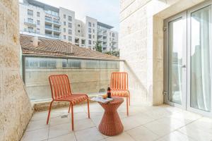 2 Stühle und ein Tisch auf dem Balkon in der Unterkunft Luxury and Large 2 Bedroom - Rav Kuk Residence in Jerusalem